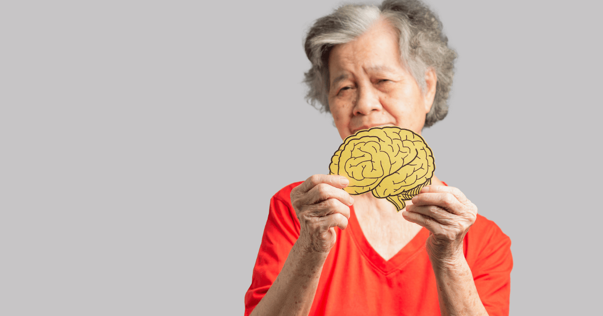 Senior woman holding human brain model to review different types of dementia.