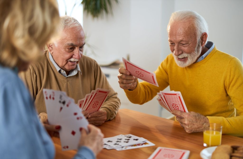 A group of senior friends playing a card game together and enjoying each other's company.