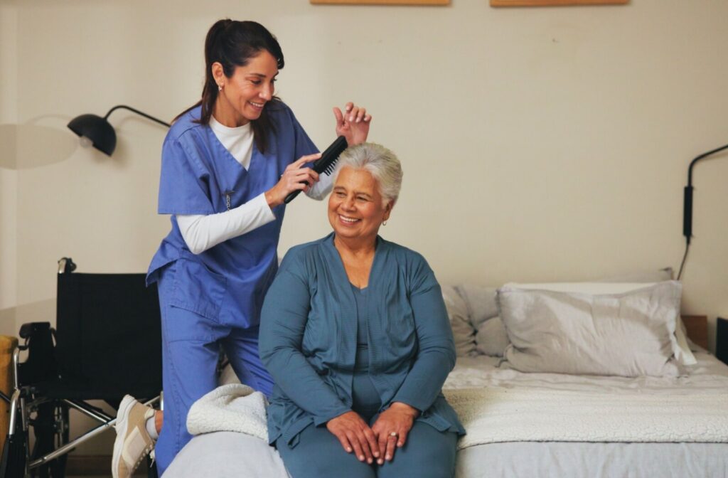 A nurse assists a senior in assisted living with getting their hair ready in the morning before partaking in group activities